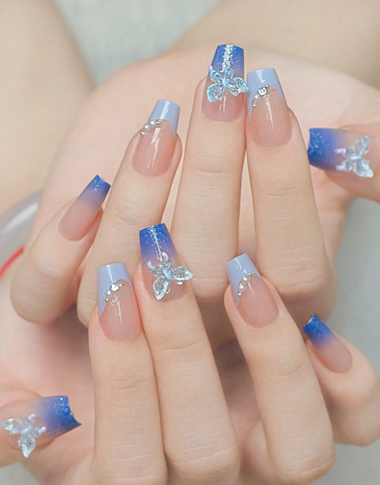 Ongles bleu avec décor 3D de perle de papillon