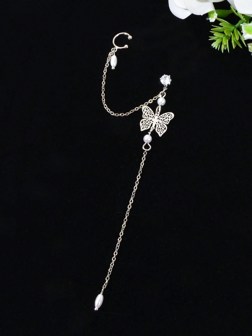 boucle d’oreille ornée d’une délicate chaîne papillon